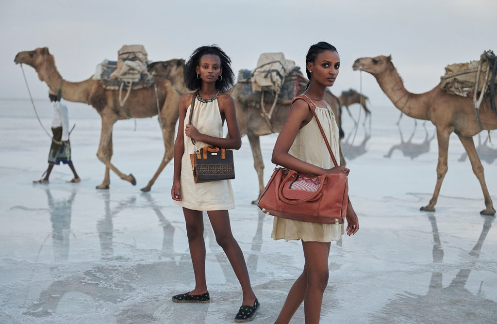 Models with ZAAF bags and camels in the background in the Afar region of Ethiopia.